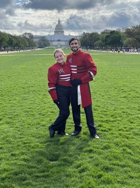 Sabrina Fredo and Ethan Farkas pose in band uniforms with the U.S. Capitol in the background