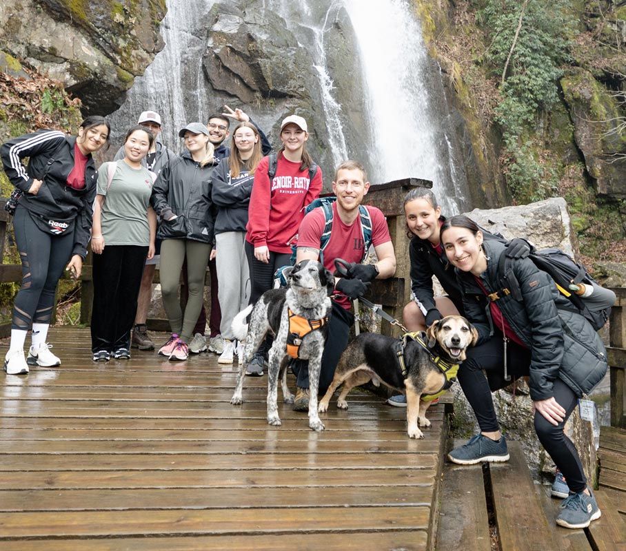 LR Outdoor Adventure Club students pose for photo in front of a waterfall while hiking