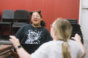 A student sings in an indoor choral classroom