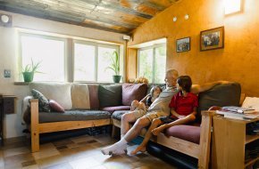 Mike Stiff sits on a couch inside his home with his two children