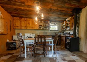 A table with four chairs sits in an kitchen with the overhead lights on