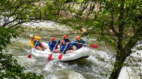 People whitewater rafting on river