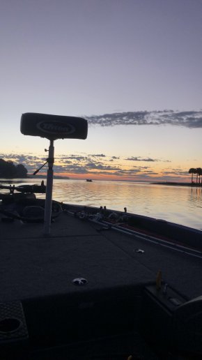 A boat sits on the water as the suns goes down