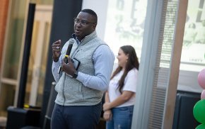 Harry Titus speaking into a microphone to a crowd