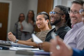 Smiling students around table in seminary classroom