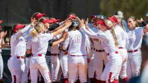 Softball team players gather as a group to celebrate big win