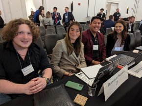 Four Model UN delegates sit behind a desk at the Southern Regional Model UN Conference