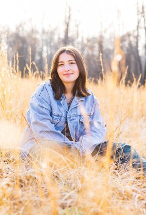 Maggie Keller sits in a field