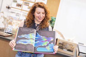 Carly York displays the pages displaying the blanket octopus in her book Queens of the Jungle