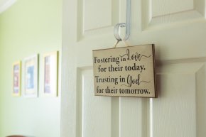 A sign hangs on a nursey bedroom door