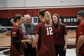 Volleyball coaches Nicole Barringer and Mark Wimberley talk with students on the court