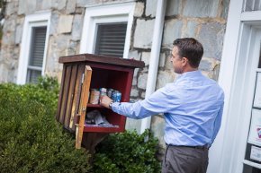 Todd Cutter places items in the food pantry outpost at the counseling and wellness center.