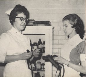 Student Mary Mitchell ’65, right, receives pediatric instruction from Mrs. Genelle Causby of the Grace Hospital nursing staff.