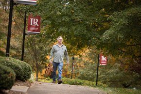 Eric Dunaway walks under the trees around the main quad