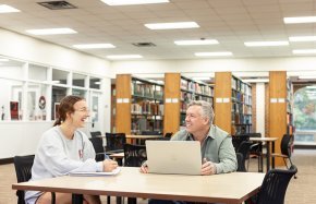 Eric Dunaway chats with a fellow student in the library study area