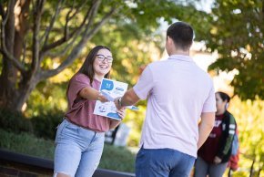 Jocelyn Florez hands out healthcare pamphlets on campus