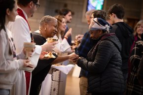 A line of seminary faculty greets and serves communion to a line of LR students and faculty in Grace Chapel