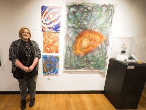 Connie Dale with her paintings at Hickory Museum of Art