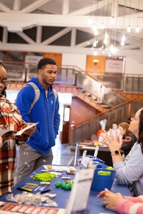 Students look at mental health resources at a table in Cromer Center lobby