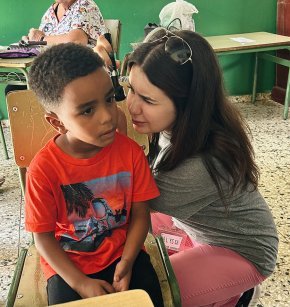 Alyssa Bailey checks the ears of a little boy during an exam