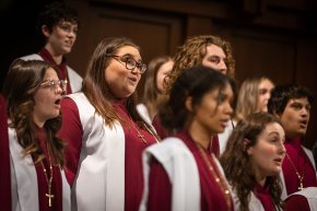 A medium shot of A Cappella Choir members in their robes, singing