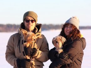 Thinh Truong with his wife holding their dogs in a snowy landscape