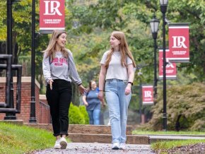 Students walking on sidewalk on campus between classes