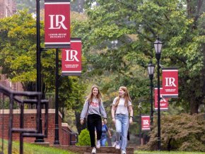 Students walking on campus with LR banners on light poles