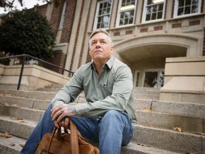 Eric Dunaway sits on the steps of the Rhyne Building