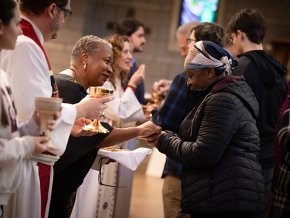 A line of seminary faculty greets and serves communion to a line of LR students and faculty in Grace Chapel