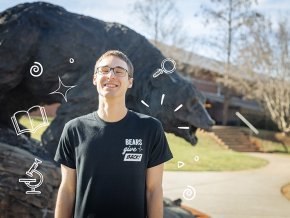 Hagan Suchocki standing in front of the Charge wearing a black Bears Give Back t-shirt