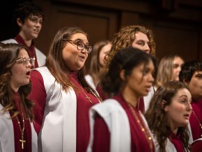 A medium shot of A Cappella Choir members in their robes, singing