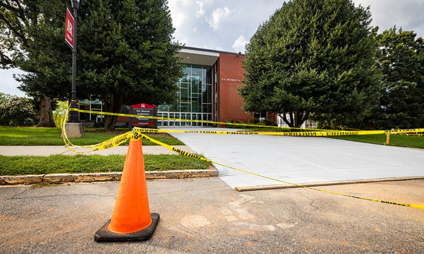 Cones and caution tape around fresh concrete in front of PE Monroe auditorium