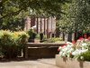 View of campus flowers and brick building in summer