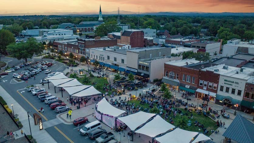 Aerial view of downtown Hickory at sunset with concert on the green by the Sails